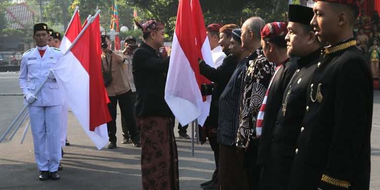 Momen saat Wali Kota Surabaya Eri Cahyadi membagikan bendera Merah Putih (Dok Diskominfo Surabaya)